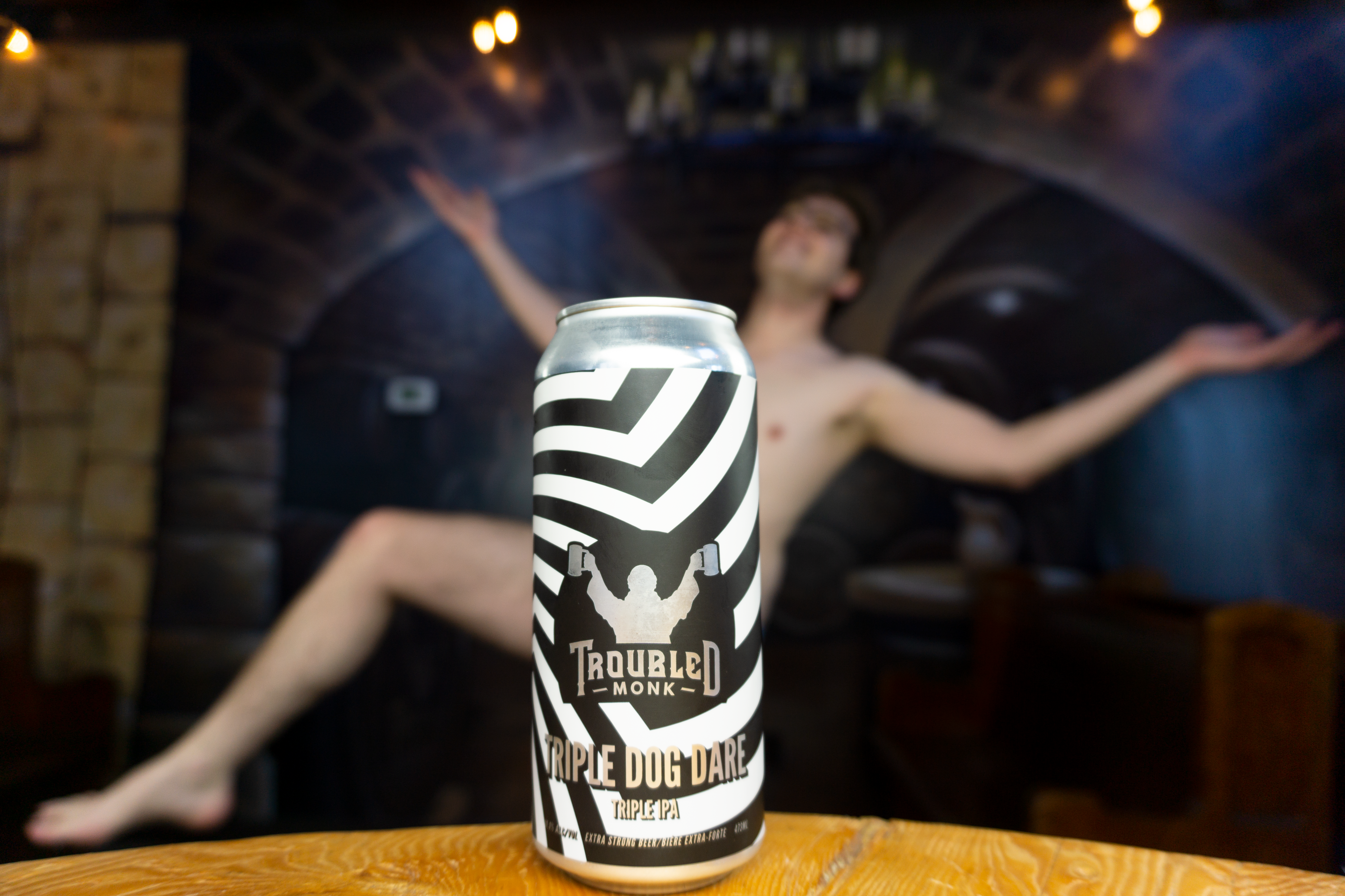 a picture of troubled monk's triple ipa with konner in the background blurred out, but seemingly naked, was he triple dog dared?